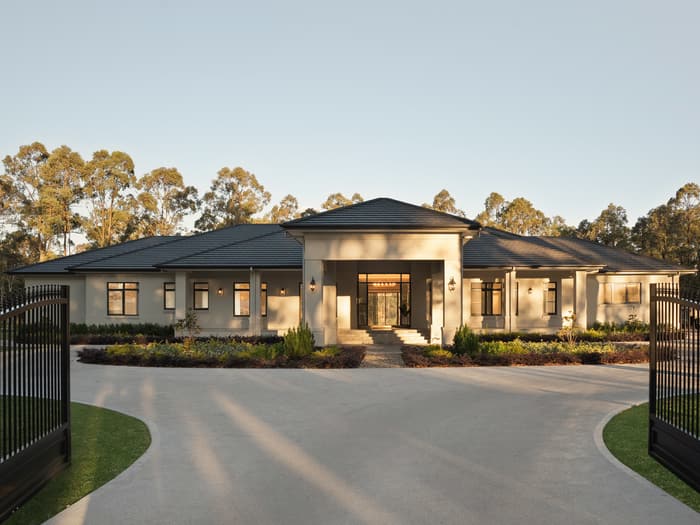Front entrance at dusk framed by the driveway gates